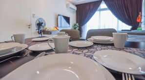 A dining table set with plates, cups, and cutlery in a hotel room. - Kuching Riverine Resort  (Kuching)