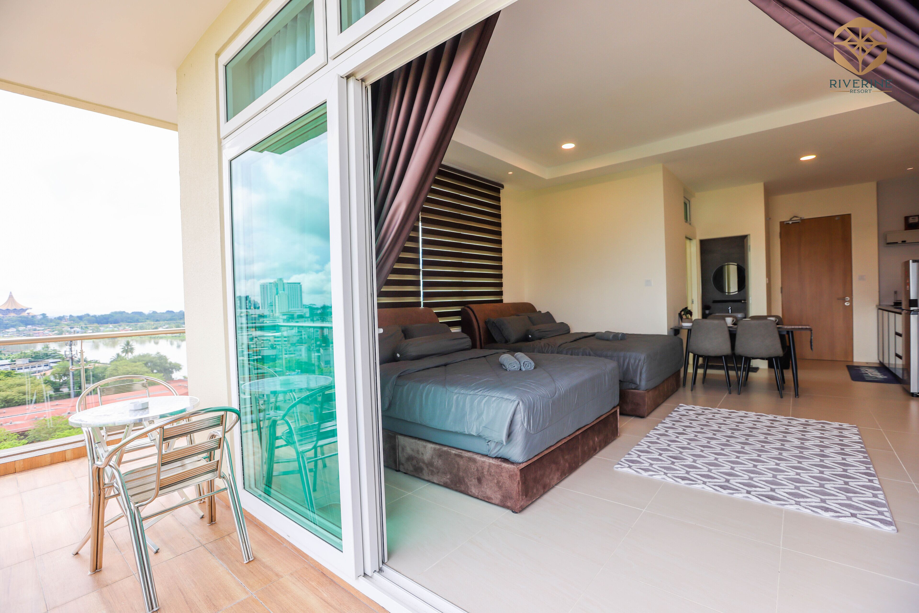 Une chambre moderne avec vue sur la ville, un balcon doté d’un coin repas et un espace de travail séparé.