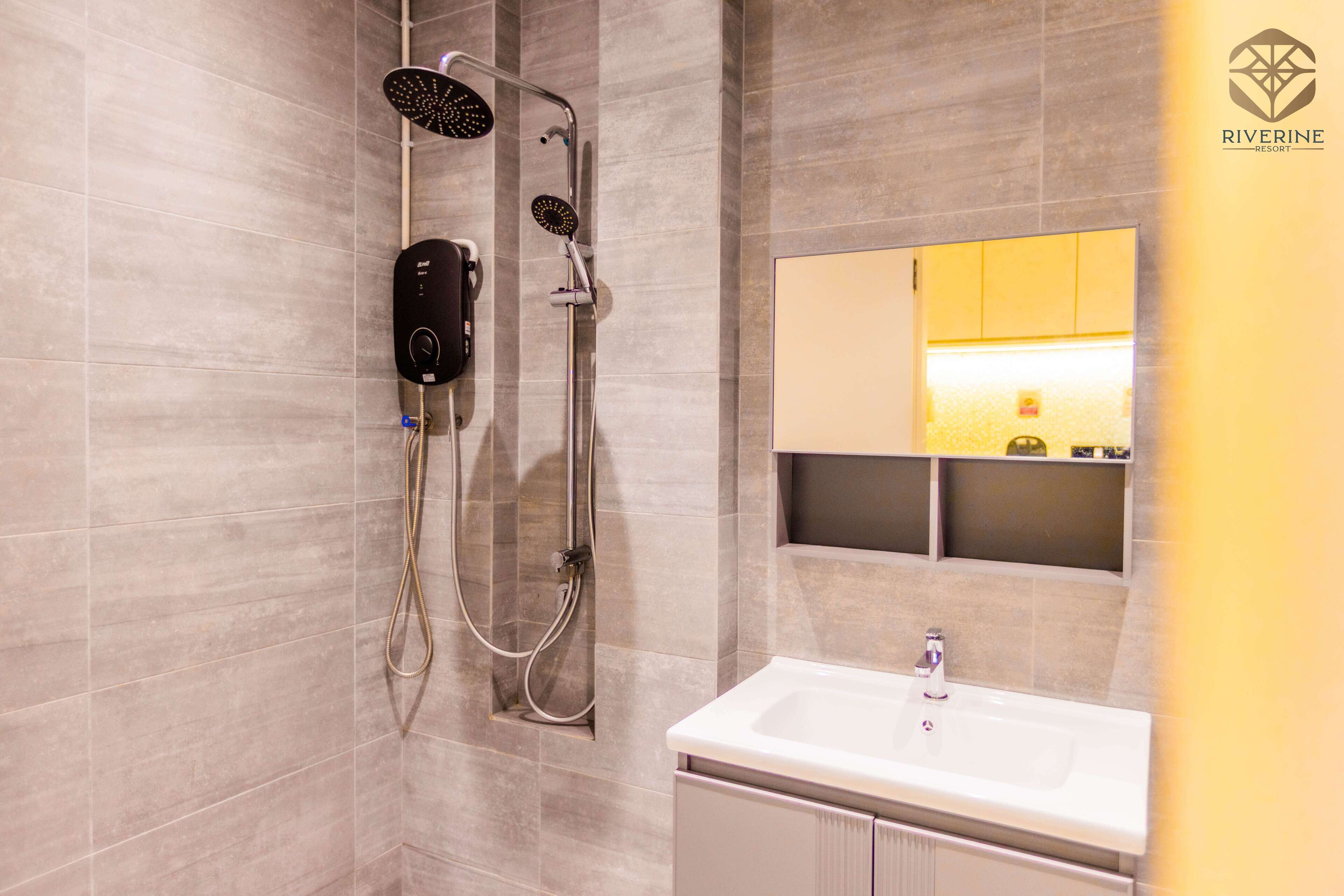 Een moderne badkamer met een douche, wastafel en spiegel.