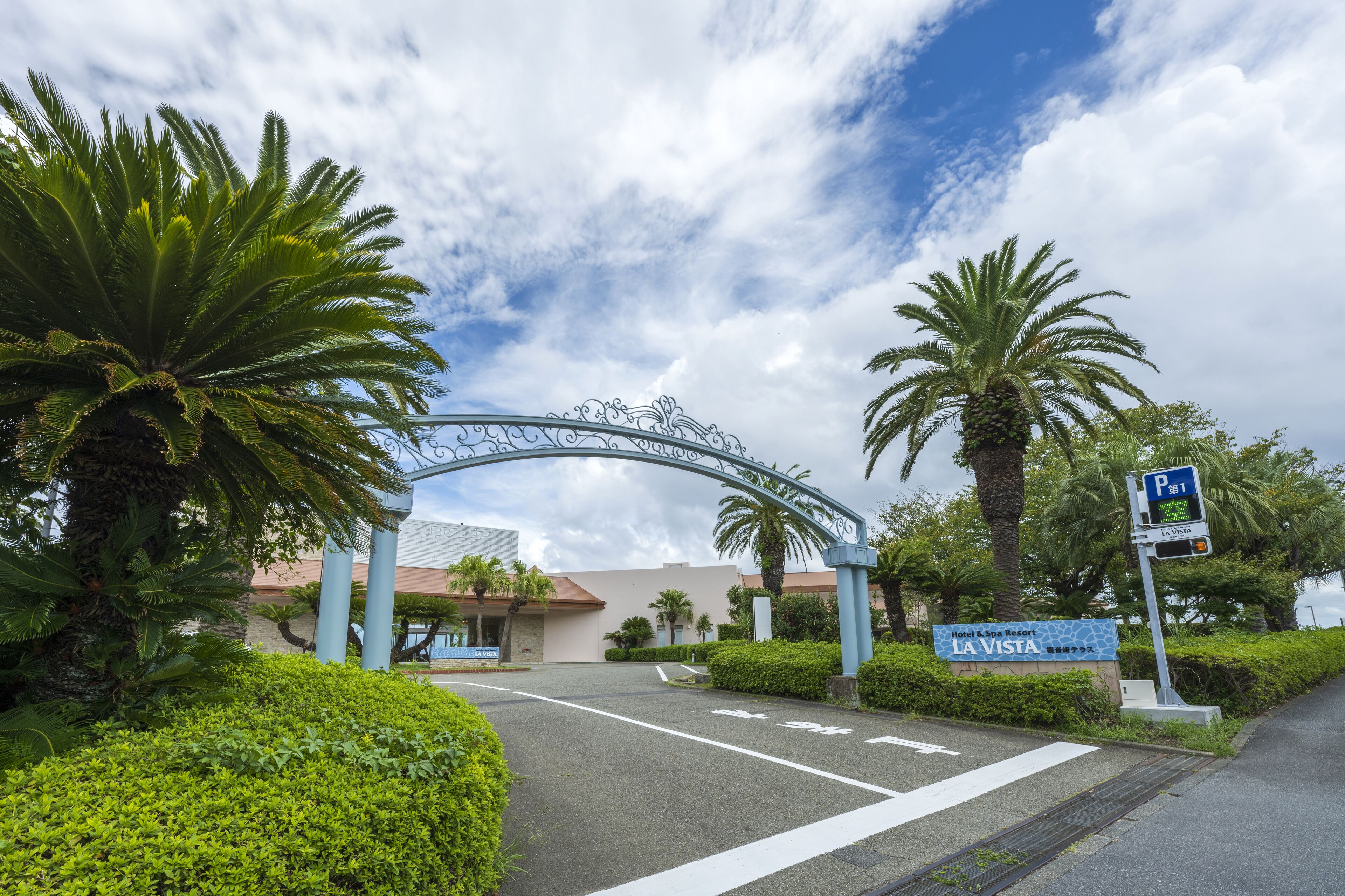 A hotel entrance with a decorative archway, palm trees, and a sign for Hotel A & Spa Resort La Vista.