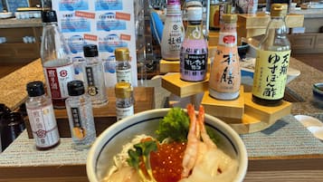 A restaurant counter with various condiments and a bowl of food.