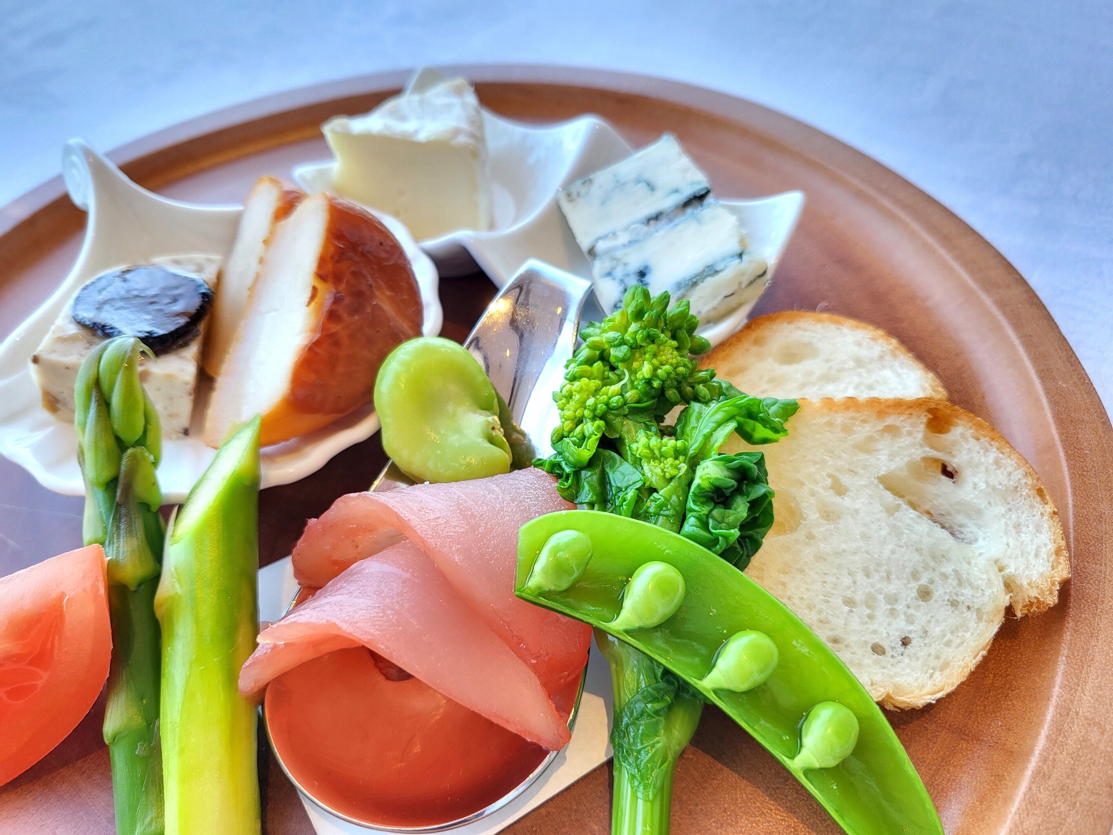 A plate with various food items including asparagus, bread, and cheese.