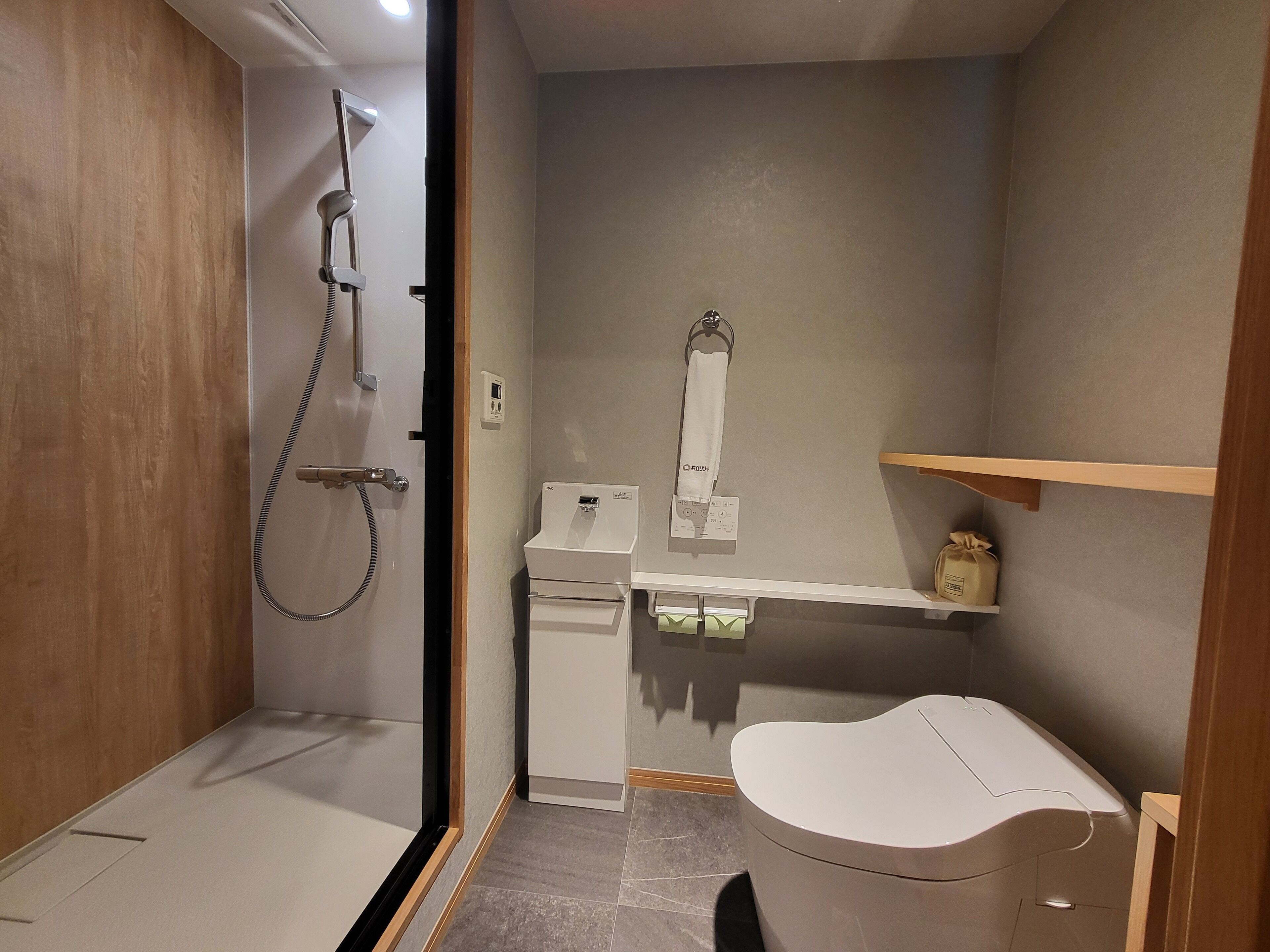 A compact bathroom with a shower, toilet, and a small sink area.