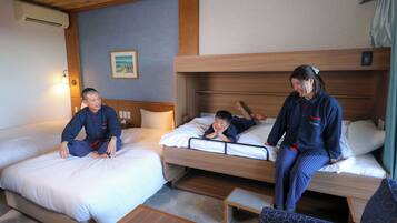 Quarto de hotel com duas camas, um sofá pequeno e teto de madeira.