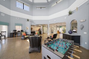 A spacious lobby with a foosball table, seating area, and a reception desk.