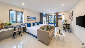 A modern hotel room with a large bed, a sofa, a desk, and a TV. - The Home Hotel & Apartment (Da Nang)
