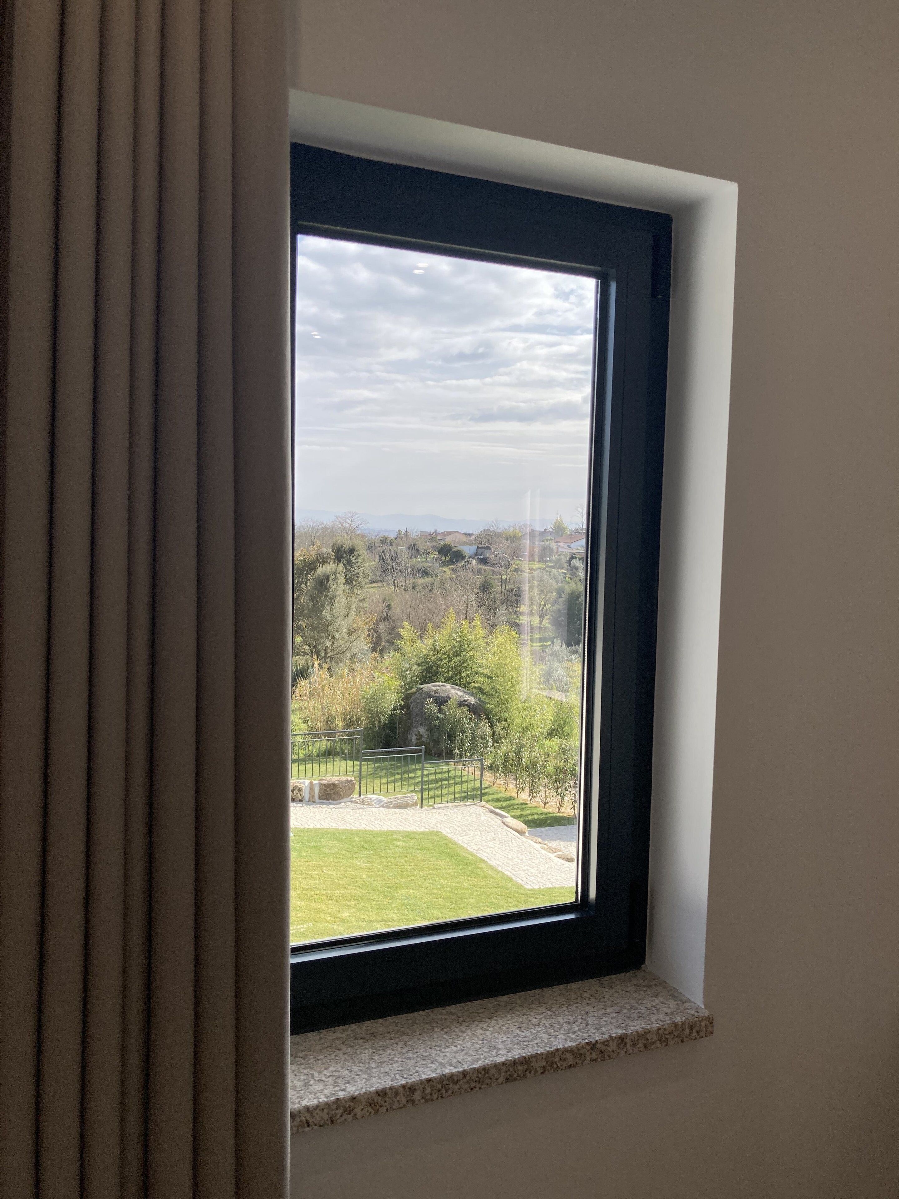 A window with a view of a grassy area and trees.