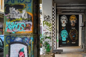 Fachada de edificio con grafitis y un mural que muestra dos rostros y texto.