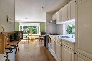 Enjoy cooking in this well-equipped kitchen with a gas stove, sink, and dining area.