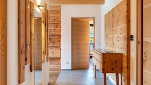 A hallway with wooden paneling, a bench, and a door leading to another room.