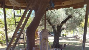 A rustic outdoor area with a fountain, a wooden structure, and a tree. - Apartment 'Agriturismo Heaven Trilocale 1' with Mountain View, Shared Pool and Wi-Fi (ricadi)