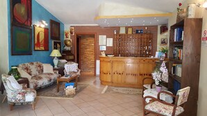 A living room with a sofa, armchairs, a coffee table, a wooden cabinet, and a bookshelf. - Apartment 'Agriturismo Heaven Trilocale 1' with Mountain View, Shared Pool and Wi-Fi (ricadi)