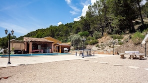A building with a tiled roof, outdoor seating, and a gravel area.