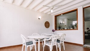 A dining area with a white table and chairs, a ceiling fan, and a large mirror. - Holiday Home "Villa Margherita" with 2 Private Terraces and Wi-Fi (Geremeas)