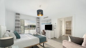 Une chambre d’hôtel moderne équipée d’un lit, d’un bureau, d’une télévision et offrant une vue sur la ville.