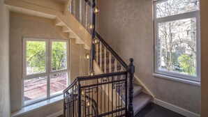 Una escalera con barandilla negra y vistas a árboles fuera.