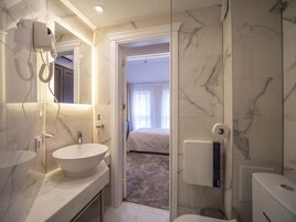 Un baño moderno con un lavamanos grande blanco, un secador de pelo y un inodoro.