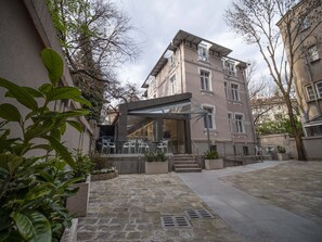 Een gebouw met een moderne architectuur, met glazen entree en een terras.