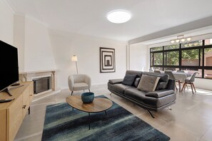 A modern living room with a sofa, coffee table, and fireplace.