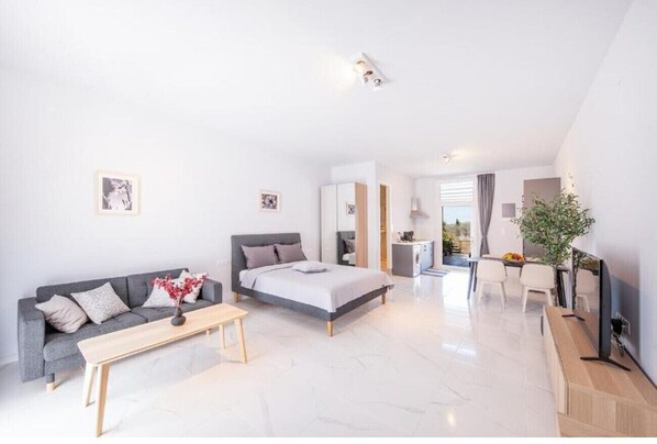 Une chambre d’hôtel moderne équipée d’un lit, d’un canapé, d’un coin repas et d’une télévision.