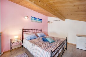 A bedroom with a bed, bedside table, and a wall-mounted light fixture.
