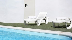 A swimming pool with two white lounge chairs and a door. - Holiday Home 'La Teja 3' with Private Pool, Wi-Fi and Air Conditioning (Vejer de la Frontera)