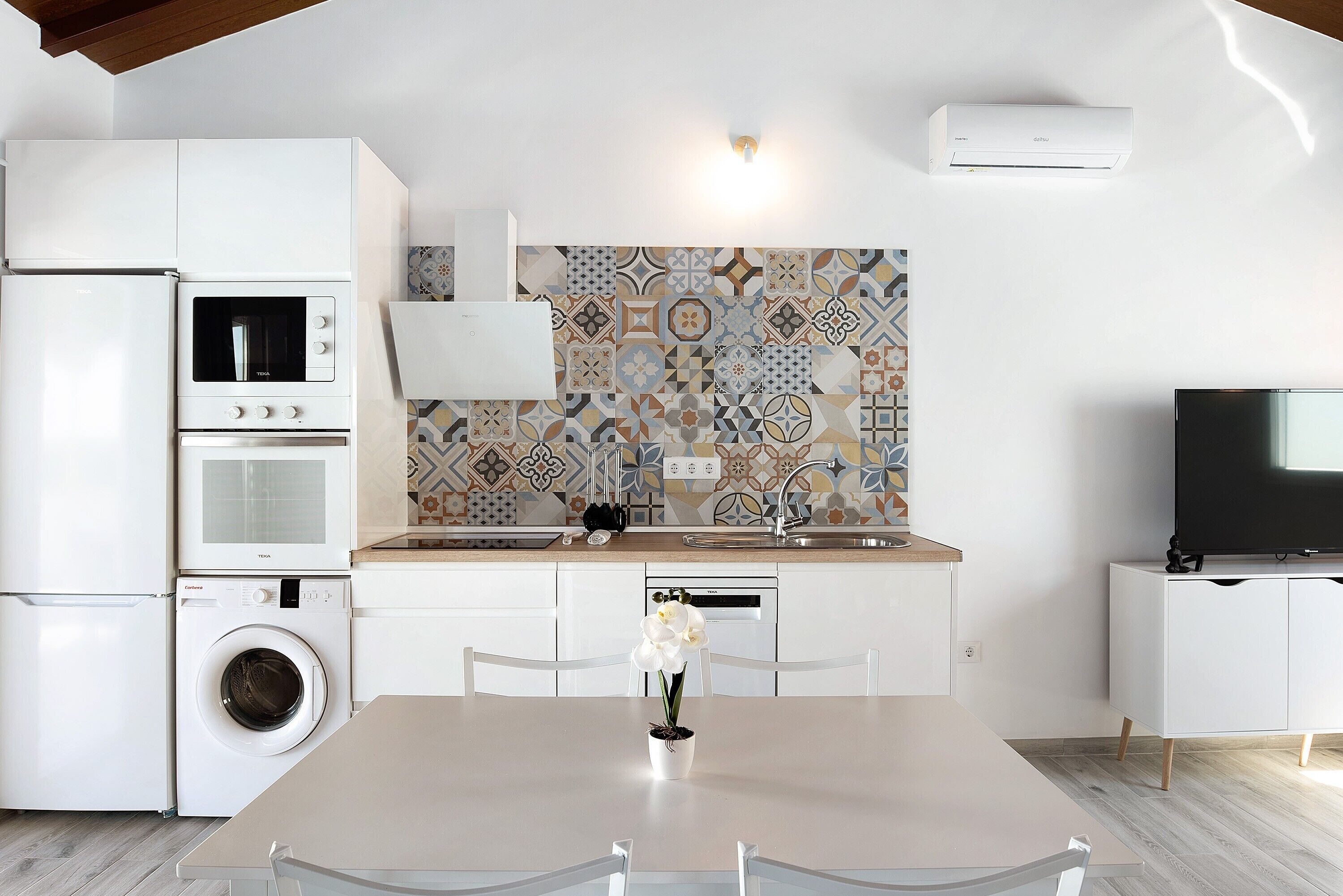 A modern kitchen with a washing machine, a microwave, and a built-in oven.