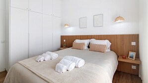 A hotel room with a bed, a wardrobe, a bedside table with a lamp, and a picture frame. - Villa "Casa da Gomeira" with Garden & Wi-Fi (Cabanas)