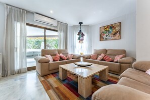 A modern living room with a sofa set, a coffee table, and a colorful rug.