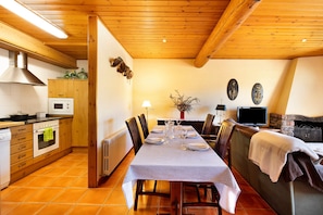 A dining area with a checkered tablecloth, wooden cabinets, a built-in oven, and a seating arrangement. - 'Mas Cal Gintó' with Mountain View, Private Terrace and Wi-Fi (Das)