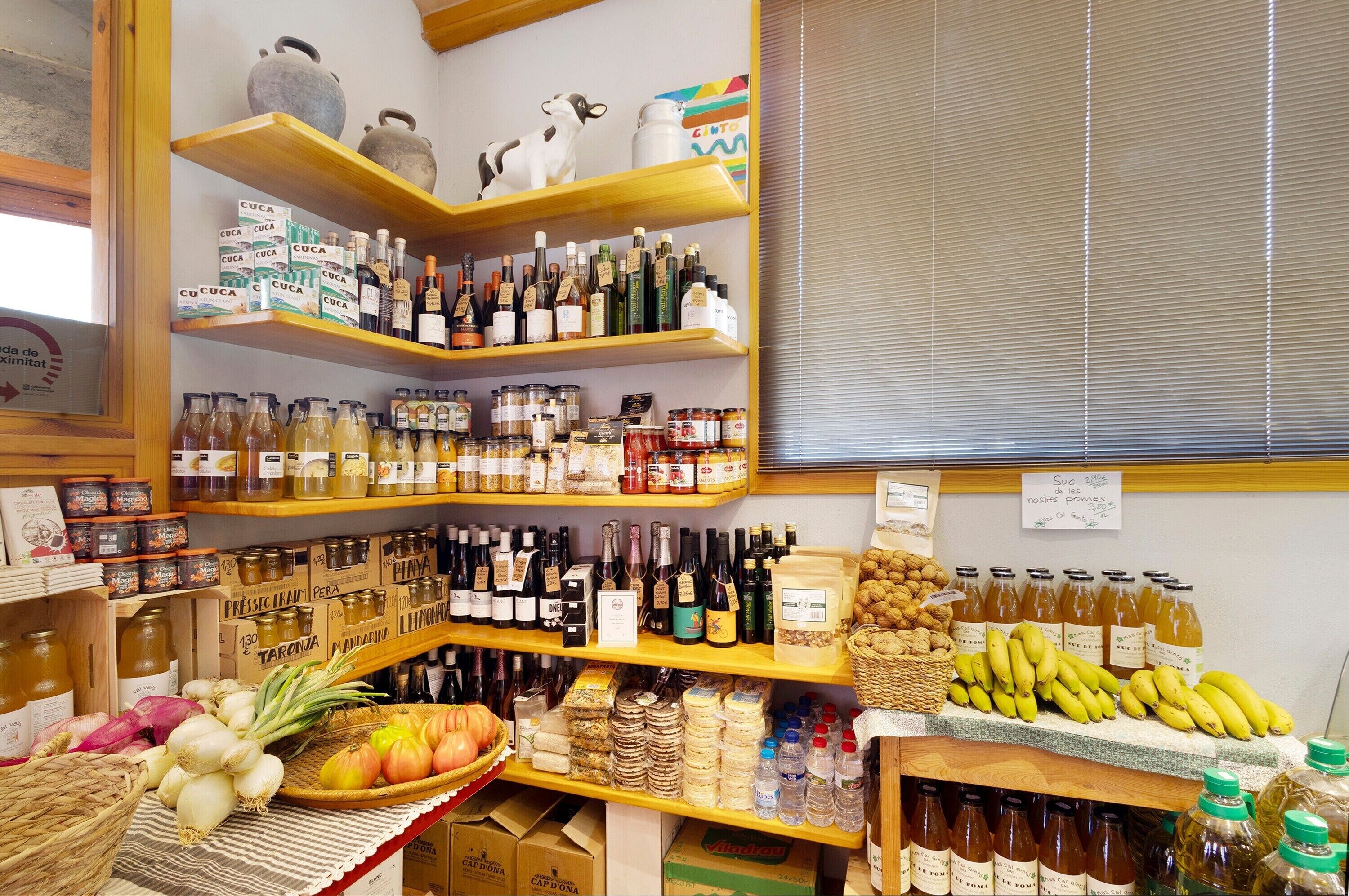 A store with shelves stocked with various products including bottles, jars, and fresh produce.
