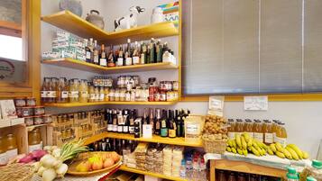 A store with shelves stocked with various products including bottles, jars, and fresh produce.