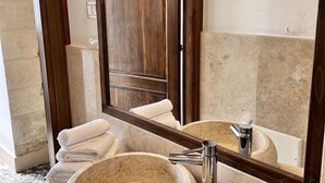 A bathroom with a large mirror, two sinks, and a stone basin. - Typical Salento romantic suite (Borgagne)