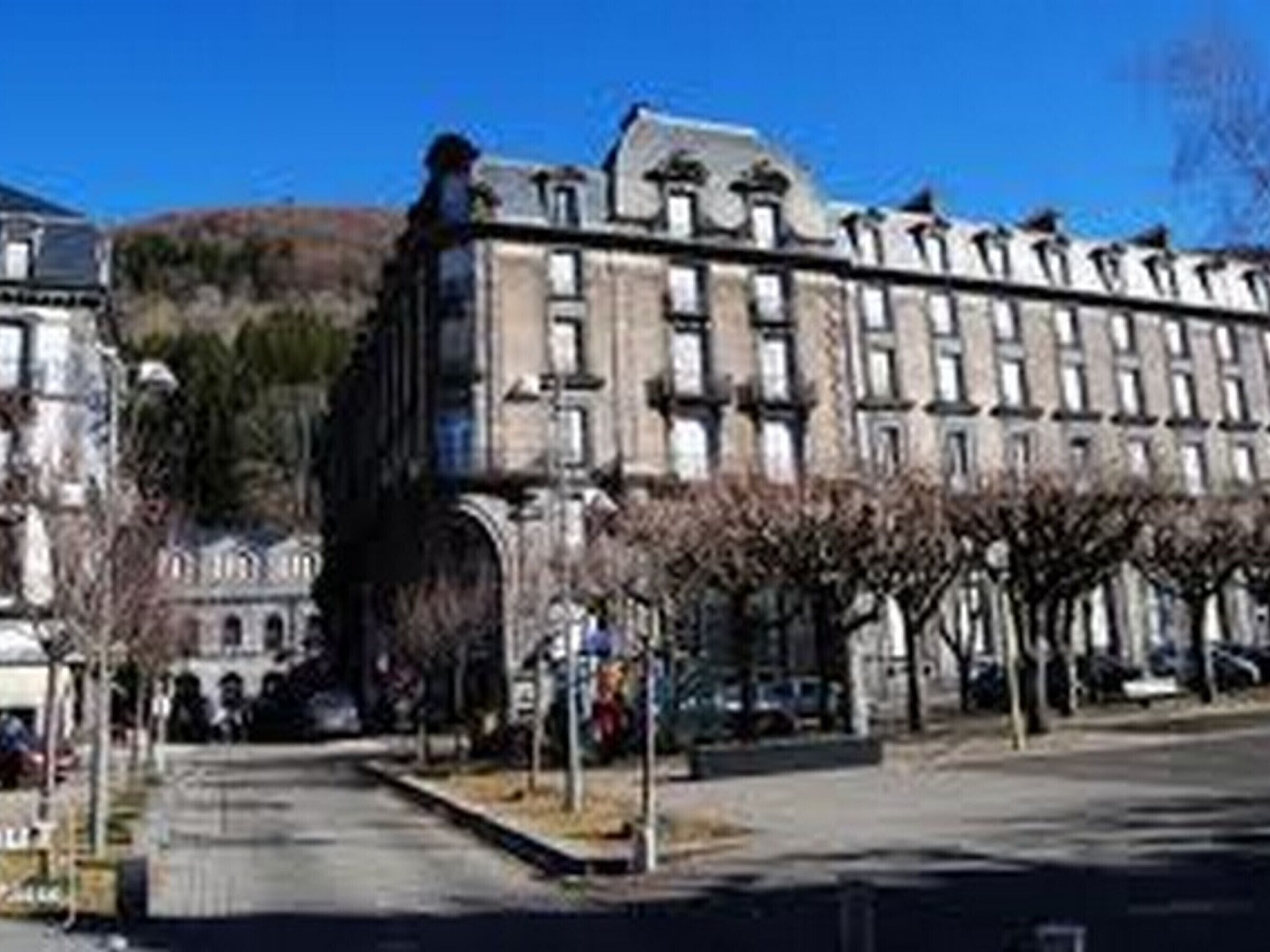 Un grand bâtiment historique, doté de plusieurs étages et d’une façade symétrique.