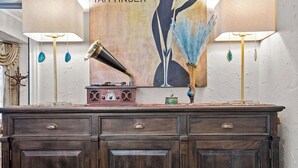 Un buffet en bois foncé, doté de nombreux tiroirs, sur lequel est posée une radio ancienne.