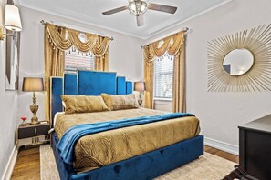 A bedroom with a large bed, two bedside tables, a ceiling fan, and a wall-mounted mirror. - The Gatsby - Gorgeous Midtown Stunner (sleeps 8) (Kansas City)