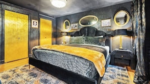 Quarto com cama, mesas de cabeceira, espelho e guarda-roupa.