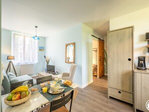 Eine moderne Küche mit Essbereich, Holzschränken und Blick zum Wohnzimmer.