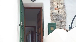 A staircase leading to a wooden door with a green gate. - Bright apartment by the sea (Grimaldi)