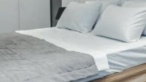 A modern bedroom with a bed, white bedding, and a wooden floor. - Innsbruck Apartment (Innsbruck)