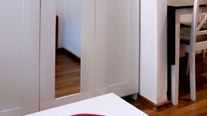 A room with a bed, a red pillow, a white wardrobe, and a desk with a chair. - Innsbruck Apartment (Innsbruck)
