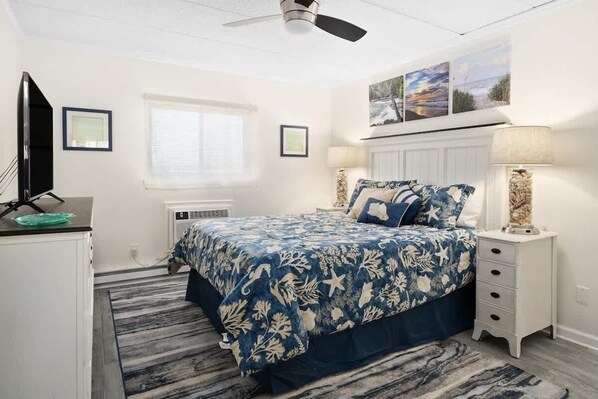 A bedroom with a bed, a desk, a chair, a window, and a ceiling fan. - Oceanblock Coral Reef Paradise (Ocean City)