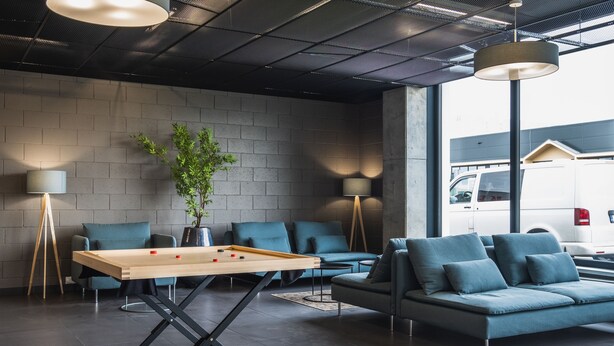 Un espace de détente moderne comprenant une table de billard, des canapés et un éclairage d’ambiance.