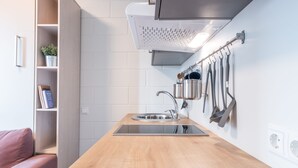 Une cuisine moderne avec un plan de travail en bois, un évier en acier inoxydable et des ustensiles de cuisine suspendus.