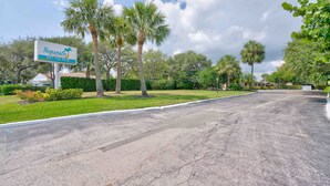 A Tequesta sign with a phone number, surrounded by palm trees and greenery. - 2 beds, Kitchenette, Free Parking - Room 2 (Tequesta)