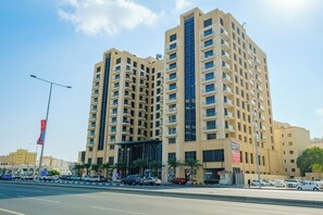 A multi-story hotel with a modern design, featuring balconies on each floor and a prominent entrance with a covered area.