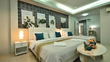 A modern bedroom with a large bed, bedside tables, a round table with decorative items, and wall-mounted artwork.