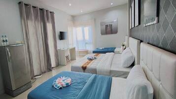 A hotel room with two beds, a desk, a television, and a wardrobe.