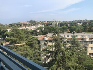 A residential area with multi-story buildings, dense greenery, and a clear sky. - MomòHouse - Sleeps 4, 2 bedrooms, Wi-Fi, air conditioning. (Mostacciano)