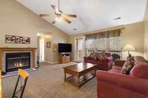 Cozy living room with a fireplace, television, and comfortable seating area.